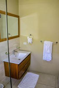 a bathroom with a sink and a mirror and towels at Water Mills- Beach Apartments in Mammee Bay