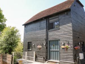 a black house with a window and a door at The Masters House in Hassocks