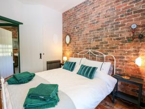a bedroom with a brick wall and a bed at The Masters House in Hassocks