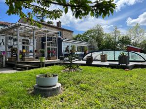 een huis met een tuin en een glazen huis bij Gite Mimosa in Saint-Florent-des-Bois