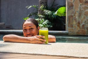 una donna stesa sul pavimento con un bicchiere di succo di Nectar Hotel, Cafe, Cowork - Adults Only a Puerto Escondido