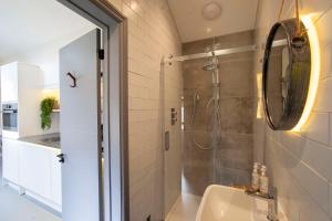 a bathroom with a shower and a sink and a mirror at higgihaus Apartment 6 Clare Street Aparthotel Central Location in Bristol