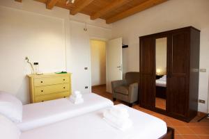 a bedroom with two beds and a chair and a mirror at Dogana in Filigare