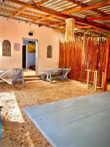 eine Terrasse mit einem Tisch und Stühlen in einem Gebäude in der Unterkunft Hostalito Lahar in Bacalar