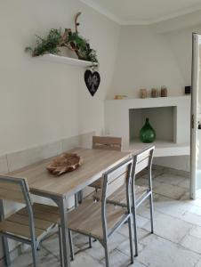 mesa de comedor con 2 sillas y mesa de madera en AleHouse, en Selva di Fasano