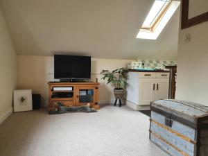 sala de estar con TV de pantalla plana en un soporte en 1 Bedroom Annexe Bagthorpe Brook Nottinghamshire, en Nottingham