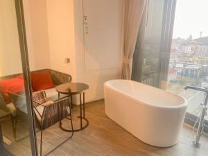 a bath tub in a room with a couch and a table at Edge Central Pattaya Vip Condo in Pattaya Central