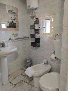 Baño blanco con aseo y lavamanos en AleHouse, en Selva di Fasano