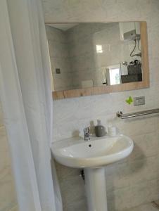 y baño con lavabo y espejo. en AleHouse, en Selva di Fasano