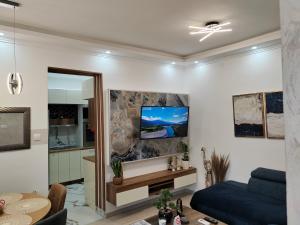 - un salon avec un canapé et une télévision murale dans l'établissement HONEYMOON APARTMAN, à Sokobanja