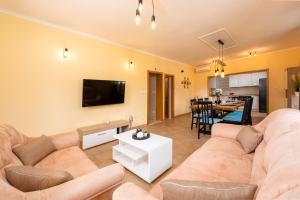 uma sala de estar com um sofá e uma mesa em Vila Vergatum-privacy,gym,billiards,table tennis em Donji Brgat