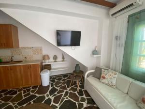 a living room with a couch and a flat screen tv at red2 guest house in Flampouria