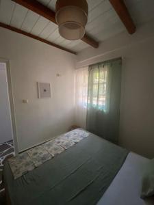 una camera con letto in una stanza con soffitto di red2 guest house a Flampouria