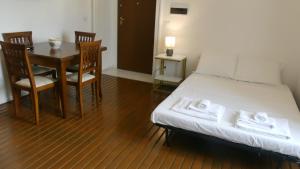 1 dormitorio con 1 cama, mesa y sillas en Marea Case per Vacanze, en Bacoli