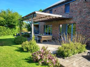 un patio con tavolo in legno in giardino di Gîte Wellness "Le Poirier" a Durbuy