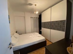 a small room with a bed and a mirror at The Blue Pearl Apartment in Durrës