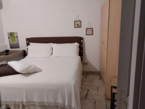 1 dormitorio con 1 cama grande con sábanas blancas en AleHouse, en Selva di Fasano