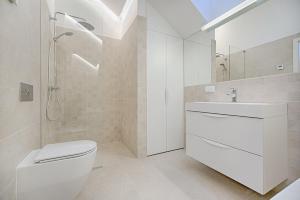 y baño con aseo, lavabo y ducha. en Thee Ibiza Suites - Ushuaia Beach, en Playa d'en Bossa