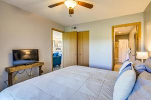 a bedroom with a large bed with a ceiling fan at Branson Escape with Pool Access, Grill and Balcony! in Branson