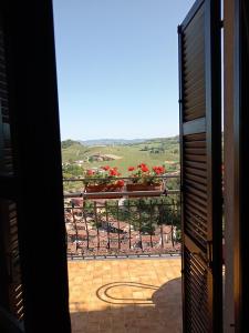 una vista dalla porta di un balcone con fiori di Teresa Belvedere Rooms&HolidayApartments Camere&Appartamenti a Castellinaldo