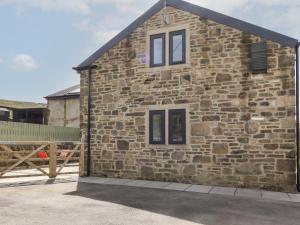 a stone house with windows on the side of it at Cuckoo Cottage in Keighley