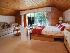 a bedroom with a bed and a large window at Llys Offa in Wynnstay