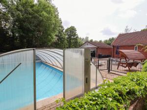 a swimming pool with a glass fence around it at Llys Offa in Wynnstay