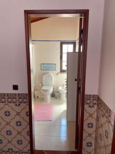 een badkamer met een toilet en een deur open bij Fountain of Happiness in Óbidos