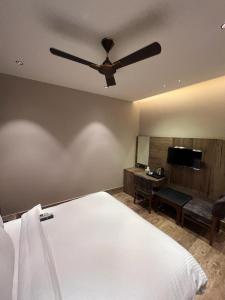 a bedroom with a bed and a ceiling fan at Hotel Ventures Inn in Amritsar
