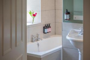 a bathroom with a sink and a toilet and a mirror at Cross Keys Inn Ettrickbridge in Ettrickbridge End