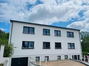 ein weißes Gebäude mit schwarzen Fenstern und einem Himmel in der Unterkunft Ferienhaus Fiete 2 in Sagard