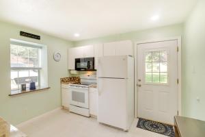 a kitchen with a white refrigerator and a window at Cozy Shenandoah Home Less Than 2 Mi to The Woodlands Mall! in The Woodlands