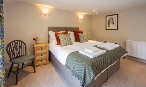 a bedroom with a large bed and a chair at Cross Keys Inn Ettrickbridge in Ettrickbridge End