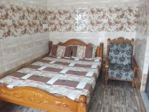 1 dormitorio con cama de madera y silla en Noah Home, en Velankanni