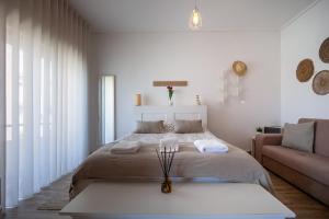 Un dormitorio blanco con una cama y un sofá. en Avenida & Mercado by Home Sweet Home Aveiro, en Aveiro