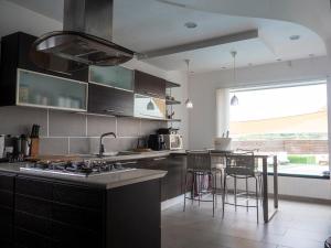 a kitchen with black cabinets and a counter with stools at Villa Patty in Naples