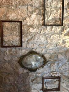 eine Steinmauer mit zwei Spiegeln darauf in der Unterkunft Authentic Vila Nona by NYC Interior Architect in Susak