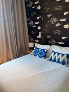 a bedroom with a bed with blue and white pillows at Hotel Princesse D'Azur in Sainte-Maxime