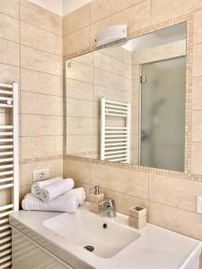 a bathroom with a sink and a mirror and towels at La Dolse Ca' - Lago di Garda in Brenzone sul Garda