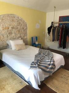 a bedroom with a large bed with a stone headboard at Authentic Vila Nona by NYC Interior Architect in Susak