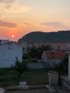 a sunset in a village with houses and trees at Authentic Vila Nona by NYC Interior Architect in Susak