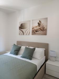 a bedroom with a bed with two pictures on the wall at GF Holiday Suite 3 in Varazze