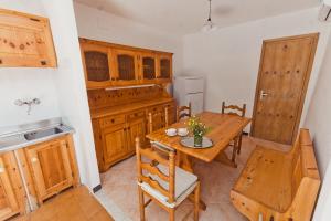 Vara Superiore的住宿－La perla nella foresta，厨房配有木桌和桌椅
