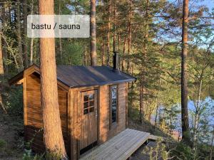 a cabin in the woods with a sign on a tree at Svanen B&B in Karlsborg