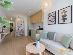 a living room and kitchen with a couch and a table at Living Las Canteras Homes - BEACHFRONT IN STYLE in Las Palmas de Gran Canaria