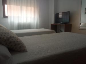 A bed or beds in a room at Hostal Cuzco