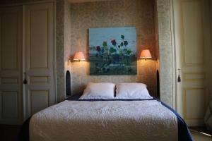 - une chambre avec un lit avec deux lampes et un tableau dans l'établissement Le Clos Chaillan, à Cinq-Mars-la-Pile
