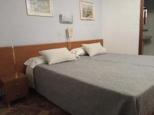 A bed or beds in a room at Hostal Cuzco