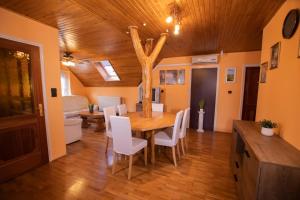 a dining room with a wooden table and white chairs at Farkas Guesthouse in Balatonszentgyörgy