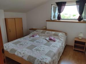 - une chambre avec un lit et 2 serviettes dans l'établissement Apartmani Danica, à Vrbnik